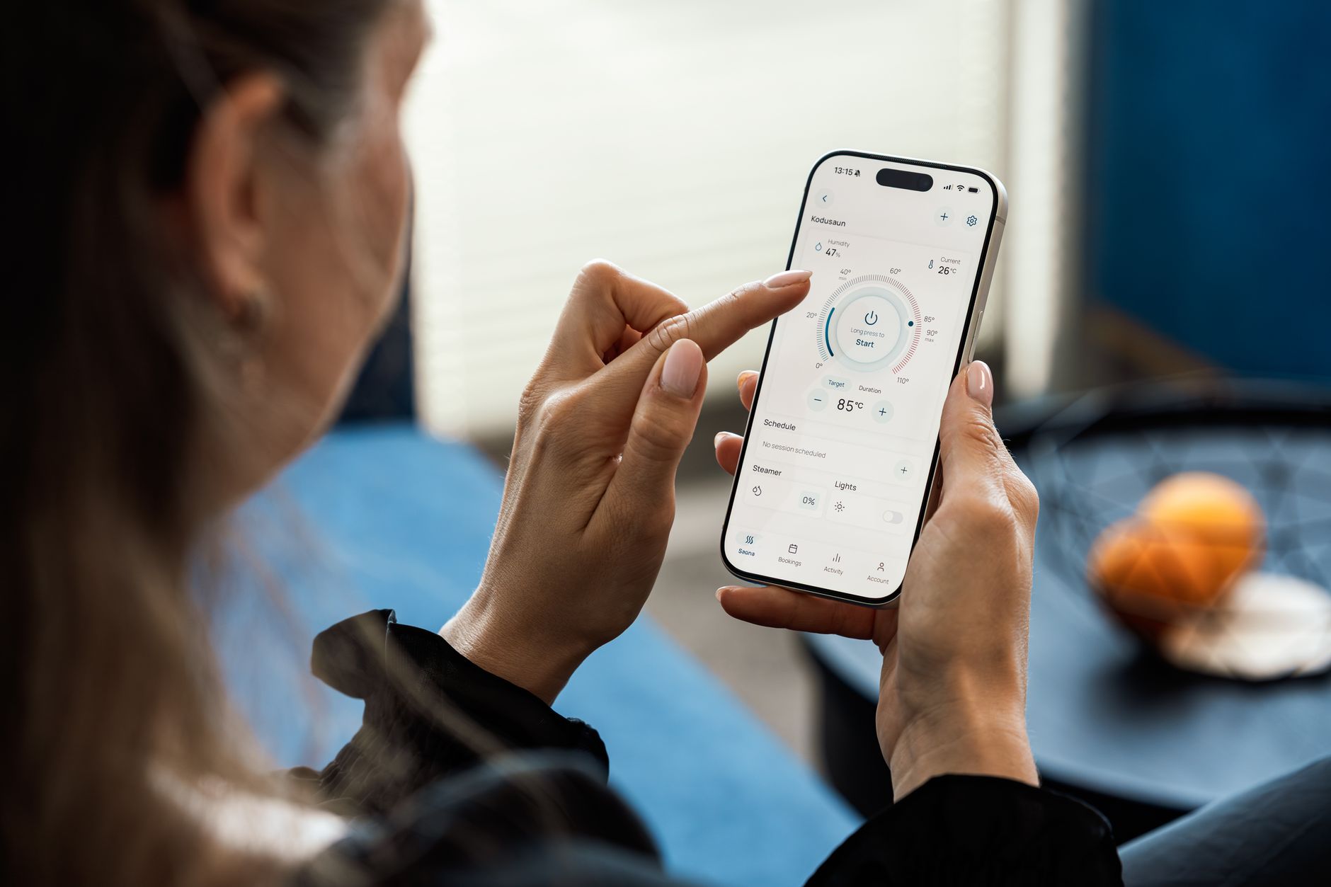 Kobieta obsługująca aplikację mobilną termostat smart home pokazującą temperaturę 85°C na ekranie